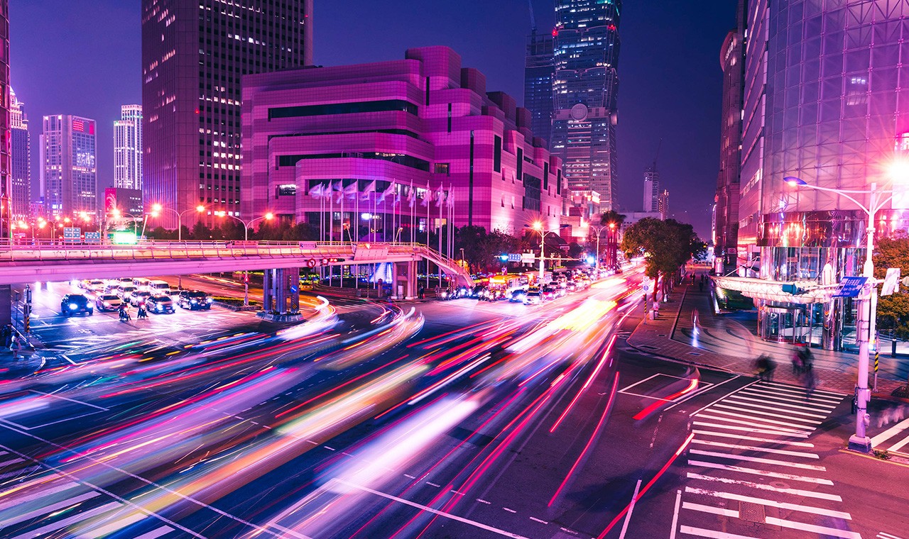 亮灯的摩天大楼与车灯光束夜景