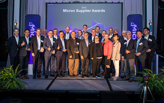 supplier-awards-page-blog-2000x500.jpg：众多合作伙伴站立在“Micron Supplier Awards”和垂直的“Micron”标语前